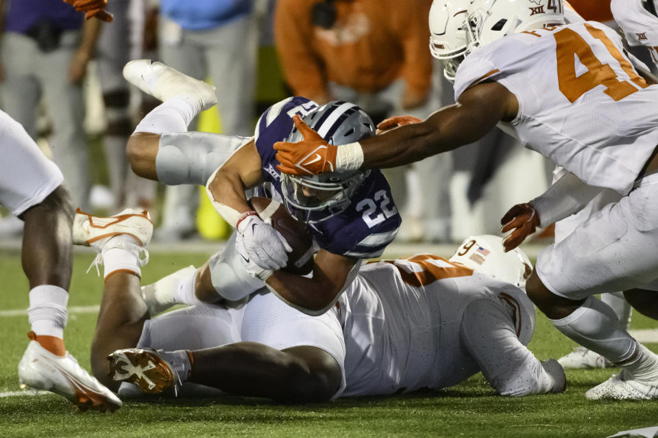 Kansas State running back Deuce Vaughn (22) is tripped up and then tackled by Texas linebacker Jaylan Ford (41) during the second half of an NCAA college football game Saturday, Nov. 5, 2022, in Manhattan, Kan. (AP Photo/Reed Hoffmann)