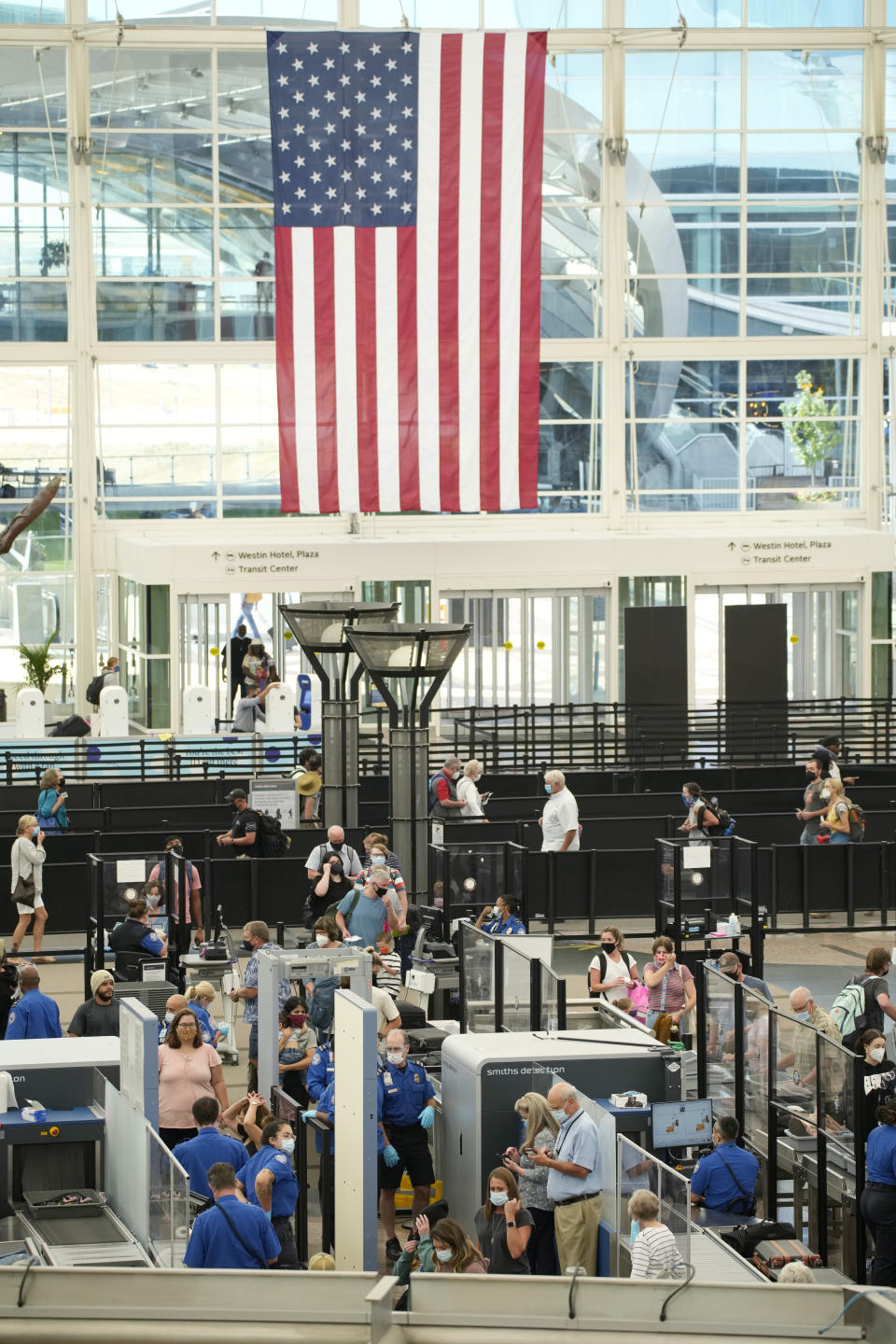 Travelers wear face coverings in the queue for the south security checkpoint in the main terminal of Denver International Airport Tuesday, Aug. 24, 2021, in Denver. Two months after the Sept. 11, 2001 attacks, President George W. Bush signed legislation creating the Transportation Security Administration, a force of federal airport screeners that replaced the private companies that airlines were hiring to handle security. (AP Photo/David Zalubowski)