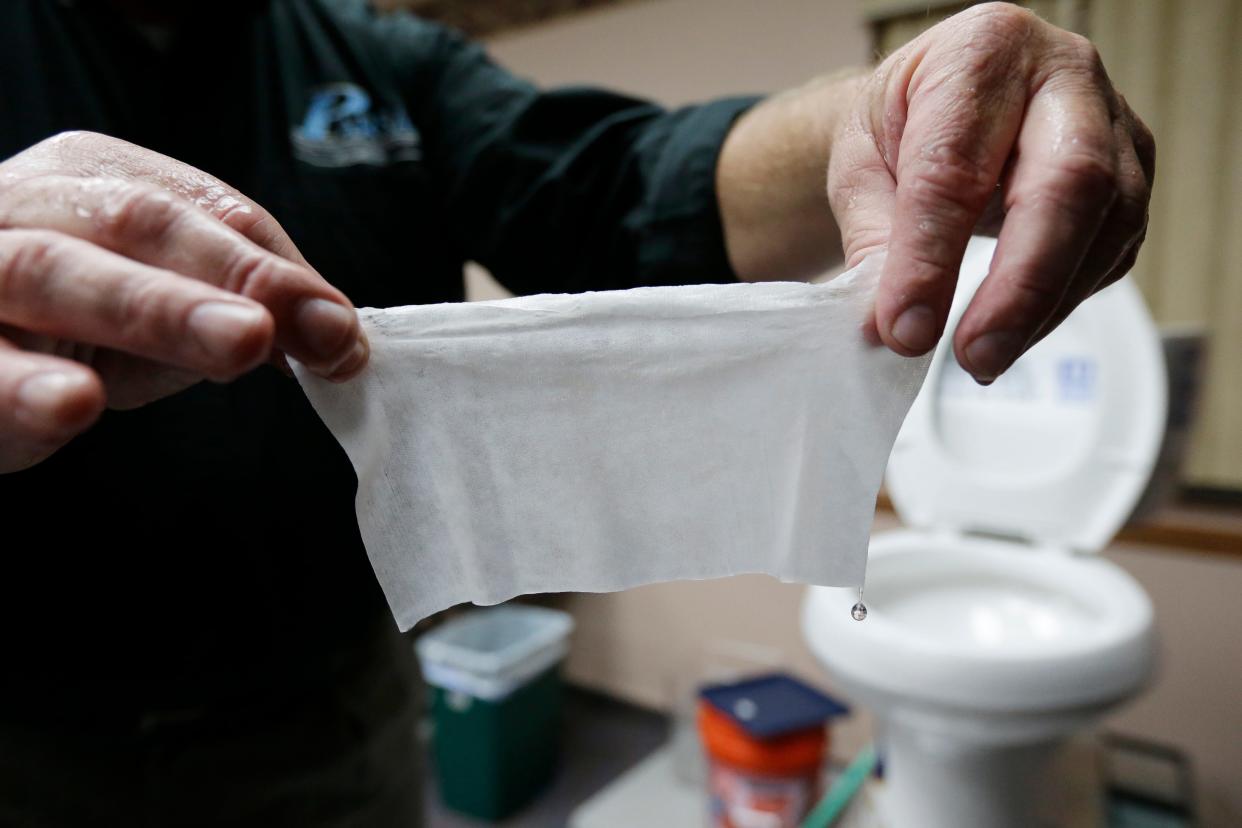 In this photograph taken Sept. 20, 2013, in Middlesex, N.J., Rob Villee, executive director of the Plainfield Area Regional Sewer Authority in New Jersey, holds up a wipe he flushed through his test toilet in his office. Increasingly popular bathroom wipes —  thick, premoistened towelettes that are advertised as flushable — are creating clogs and backups in sewer systems around the nation.