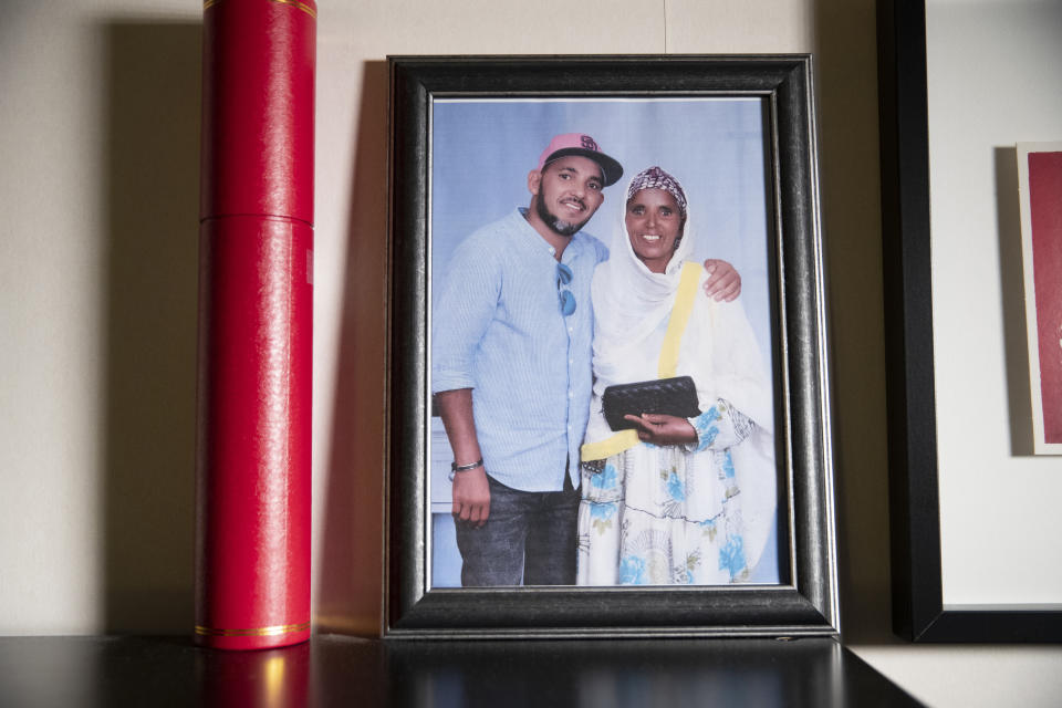 A photograph of Desta Haileselassie and his mother, Amlishaway, sits on his bookshelf in Stockholm, Sweden, on Monday, Oct. 18, 2021. Desta hasn’t spoken with her since June 27, when the phone no longer rang through in a new blackout. Since then, every day’s attempt has met silence. (AP Photo/Nat Castaneda)