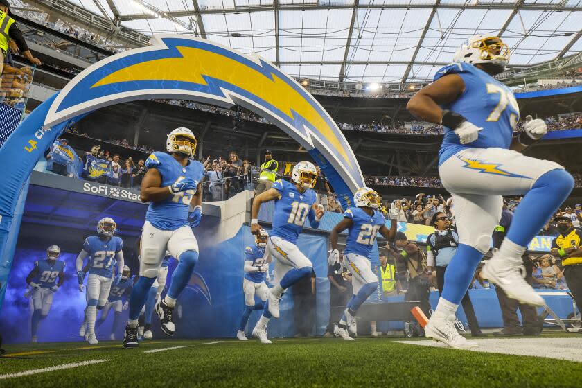 Chargers quarterback Justin Herbert (10) runs onto the field before a home game against the Bears.