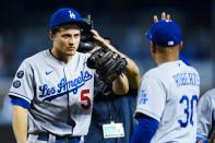 Los Angeles Dodgers shortstop Corey Seager (5) gets a high-five from Dodgers manager Dave Roberts (30) after a baseball game against the Arizona Diamondbacks, Sunday, Sept. 26, 2021, in Phoenix. The Dodgers defeated the Diamondbacks 3-0. (AP Photo/Ross D. Franklin)