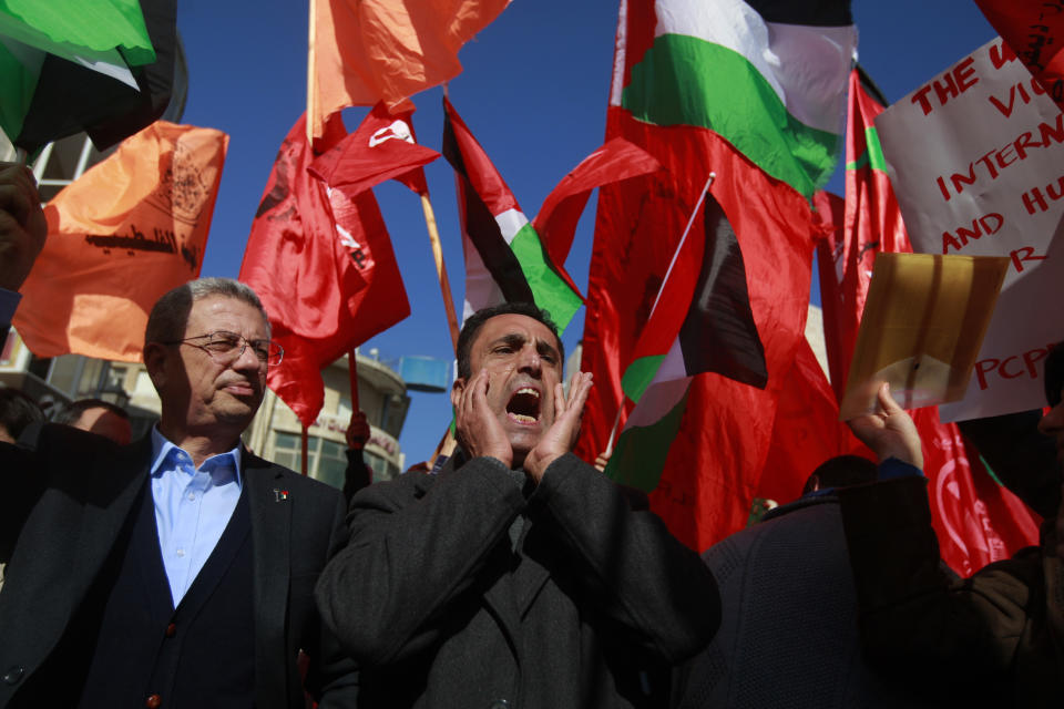 Palestinian protesters waving national and Popular Front for the Liberation of Palestine flags chant slogans during a demonstration against U.S. Secretary of State John Kerry in the West Bank city of Ramallah, Wednesday, Jan. 15, 2014. (AP Photo/Majdi Mohammed)