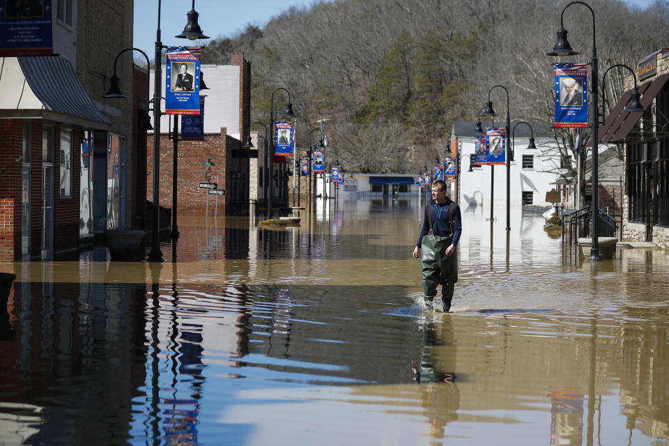 Brad Newnam, of Beattyville, Ky., crosses a flooded East Main Street while checking on businesses in the area in downtown Beattyville, Ky., Tuesday, March 2, 2021. Heavy rains caused the Kentucky River to flood most of downtown Beattyville. (Alex Slitz/Lexington Herald-Leader via AP)