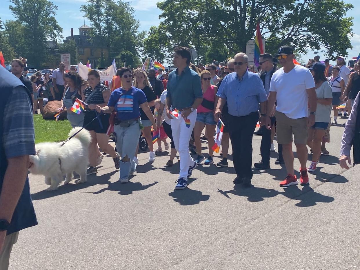 Prime Minister Justin Trudeau marches in the P.E.I. Pride parade Saturday alongside Pride P.E.I. board chair Lucky Fusca, left, and MP Lawrence MacAulay. (Stacey Janzer/CBC - image credit)