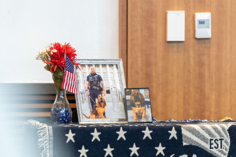 A photo of memorial decoration including a picture of K9 Bruce and his handler and K9 Bruce as a puppy (SLCPD photo – April 17, 2024).