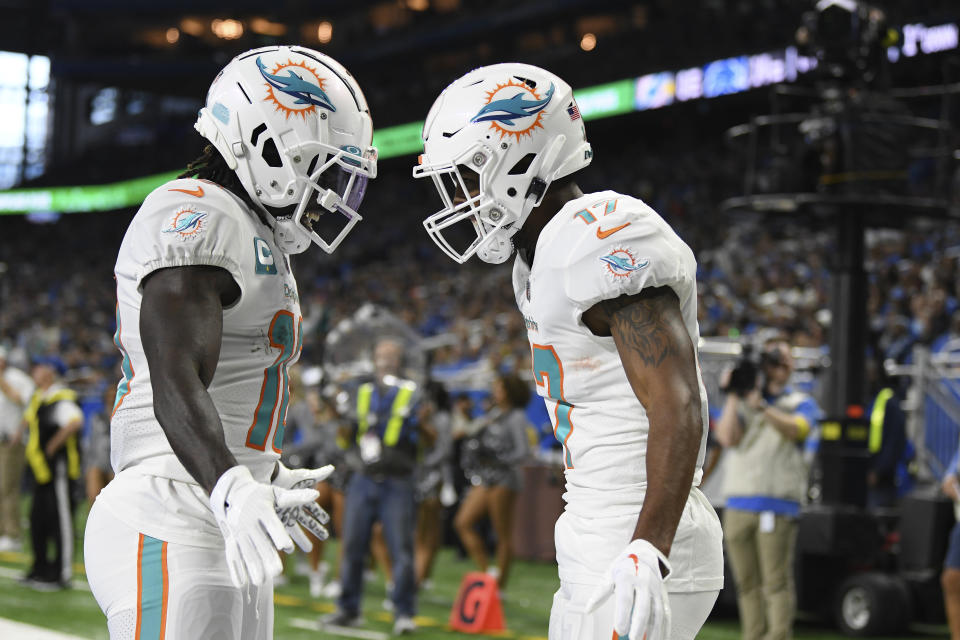 Miami Dolphins wide receiver Jaylen Waddle, right, greets wide receiver Tyreek Hill after catching a 5-yard pass for a touchdown during the first half of an NFL football game against the Detroit Lions, Sunday, Oct. 30, 2022, in Detroit. (AP Photo/Lon Horwedel)
