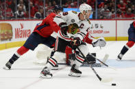 Chicago Blackhawks center Jonathan Toews (19) skates with the puck against Washington Capitals center Nic Dowd, back left, during the second period of an NHL hockey game Thursday, Dec. 2, 2021, in Washington. (AP Photo/Nick Wass)