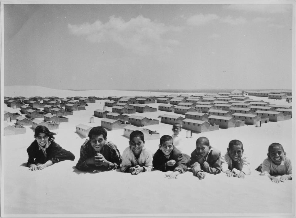 In this 1971 photo from the U.N. Relief and Works Agency, UNRWA, archive, Palestinian refugees pose for picture in the New Amman refugee camp in Eastern Jordan. The photo is part of UNWRA's vast photo archive being digitized in Gaza and Denmark to preserve a record of one of the world's most entrenched refugee problems, created in what the Palestinians call the "Nakba," or “catastrophe”-- their uprooting in the war over Israel's 1948 creation. (AP Photo/G.Nehmeh, UNRWA Photo Archives)