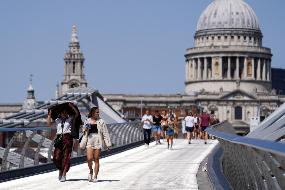 high streets People cover themselves from the sun at Millennium Bridge during a heatwave, in London, Britain, July 18, 2022. REUTERS/Maja Smialkowska