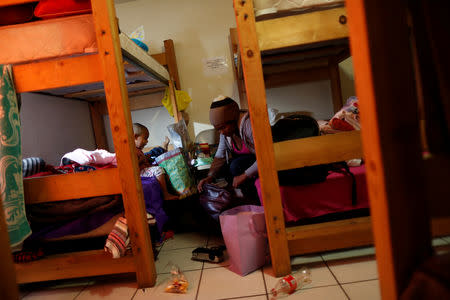 Honduran migrant Erly Marcial, 21, organises her belongings next to her husband Alvin Reyes, 39, and their sons David, 2, and newborn Alvin, in the dormitory of a church where they are staying in Tijuana, Mexico, December 4, 2018. REUTERS/Carlos Garcia Rawlins