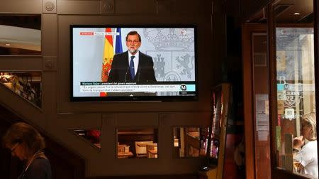 Spain's Prime Minister Mariano Rajoy is seen delivering a statement on a television screen at a bar in Barcelona, Spain, October 11, 2017. REUTERS/Susana Vera