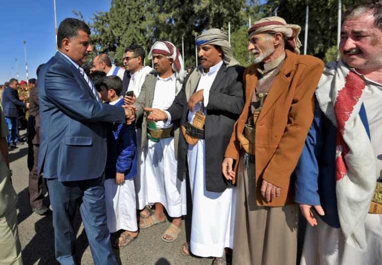 A member of the Huthi delegation (L) returning from peace talks in Sweden shakes hands with supporters upon arrival at Sanaa International Airport in the Yemeni capital on December 14, 2018