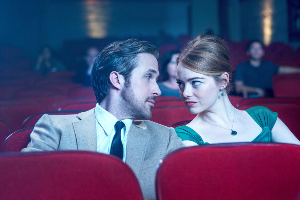 Ryan Gosling and Emma Stone looking at each other in a movie theater