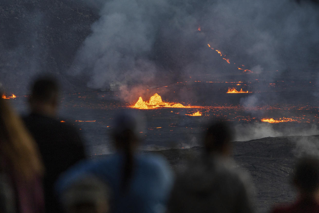 Spectators observe lava from the eruption.