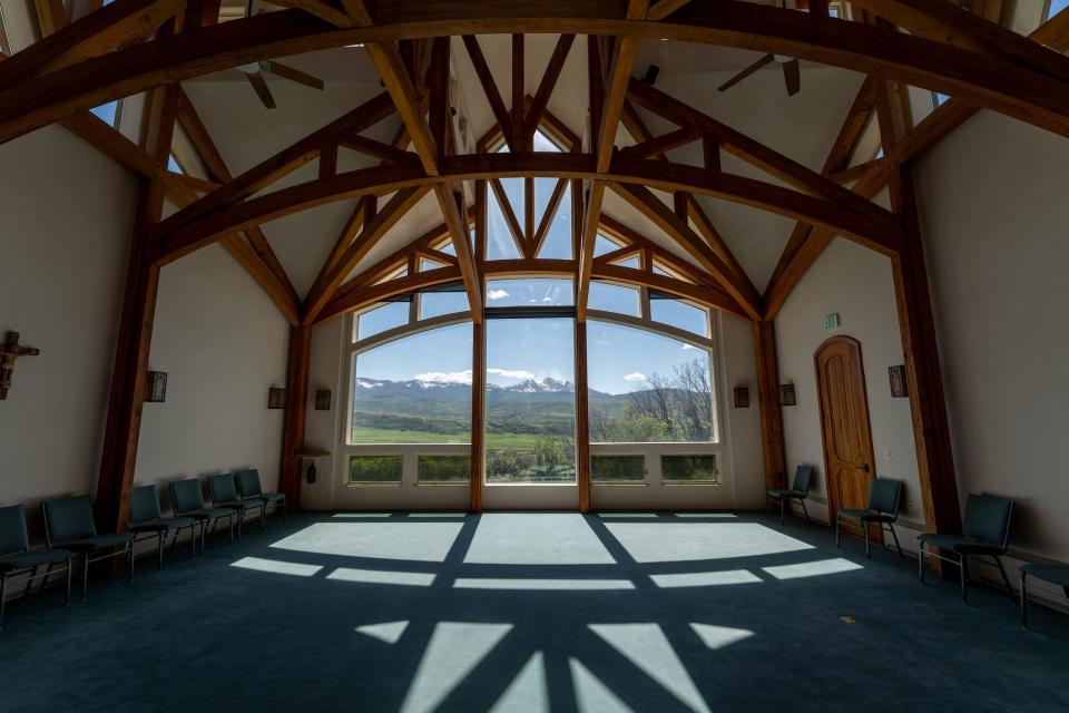 The interior of a monastery with a large glass window.