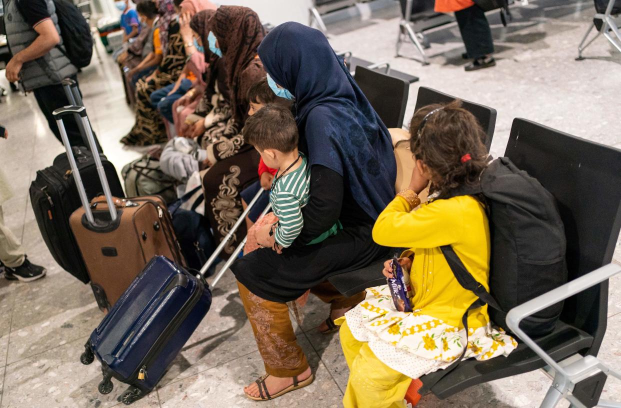 Afgan refugees wait to be processed after arriving on an evacuation flight from Afghanistan, at Heathrow Airport, London on August 26, 2021. - A terrorist threat against Kabul airport is 