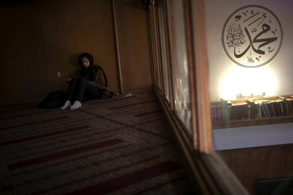 Dania Darwish, 27, director of the Asiyah Women's Center and a volunteer with Muslims Giving Back reads her Quran between volunteering work, at the Muslim Community Center in the Bay Ridge neighborhood of Brooklyn, New York, on Monday, April 27, 2020. (AP Photo/Wong Maye-E)