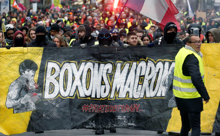 Protesters wearing yellow vest hold a banner during a demonstration of the "yellow vests" movement in Nantes, France, January 26, 2019. Banner reads: "Let's box Macron" REUTERS/Stephane Mahe