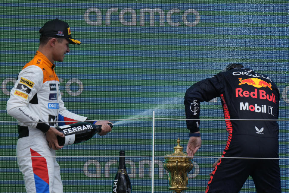 McLaren driver Lando Norris of Britain, left, sprays champagne on Red Bull driver Max Verstappen of the Netherlands celebrates his second place after the British Formula One Grand Prix race at the Silverstone racetrack, Silverstone, England, Sunday, July 9, 2023. (AP Photo/Luca Bruno)