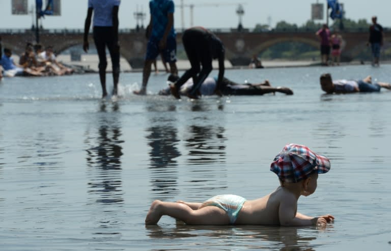 A child plays in a public fountain in Bordeaux, on June 30, 2015, as a major heatwave spreads through Europe