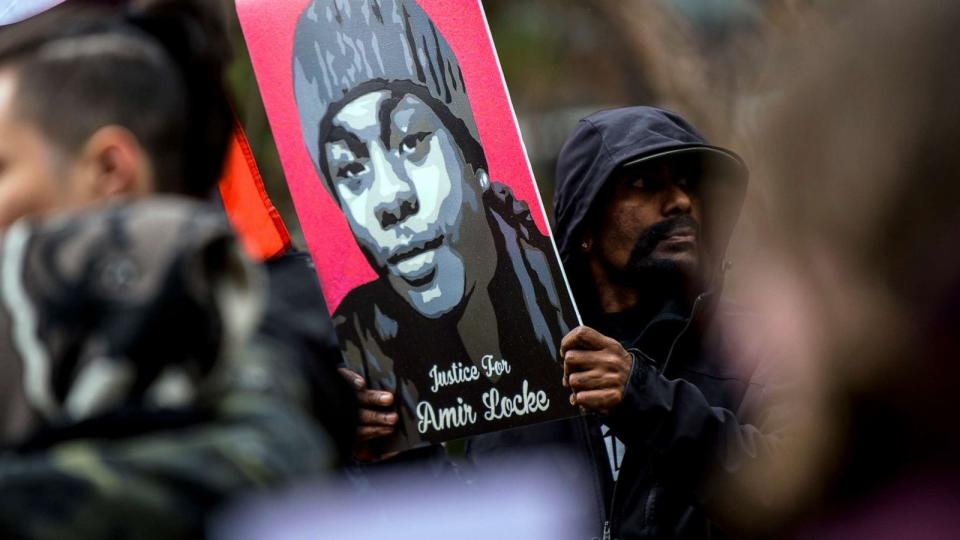 PHOTO: A man holds a portrait of Amir Locke during a news conference outside the Hennepin County Government Center on April 6, 2022, in Minneapolis. (Stephen Maturen/Getty Images, FILE)