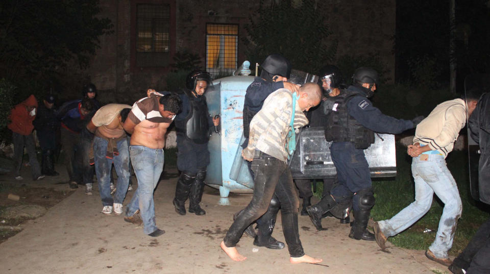 Police officers escort students involved in campus takeover after a clash in Tiripetío, Michoacan state, Mexico, Monday, Oct. 15, 2012. Police raided three teachers colleges on Monday in the western state of Michoacan, where dozens of students had been hijacking buses and delivery trucks for a week to protest curriculum changes. (AP Photo)