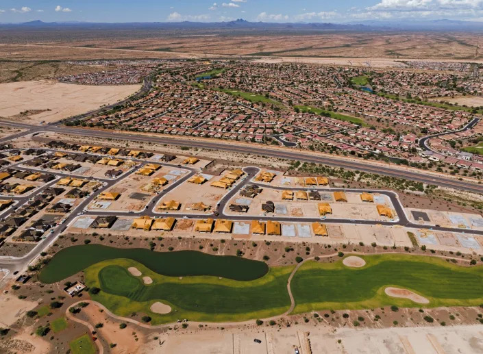 Overhead view of homes being build around a green golf course