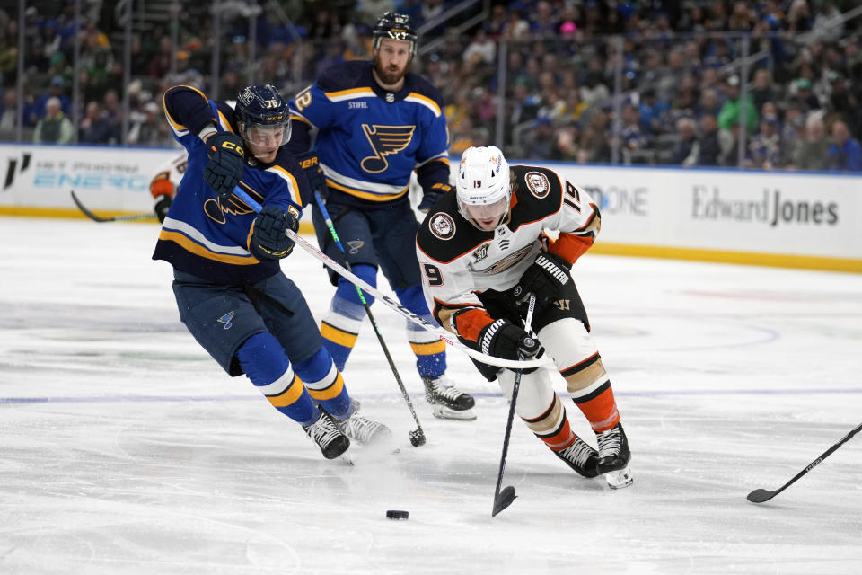 Anaheim Ducks' Troy Terry (19) and St. Louis Blues' Zack Bolduc (76) battle for a loose puck during the third period of an NHL hockey game Sunday, March 17, 2024, in St. Louis. (AP Photo/Jeff Roberson)