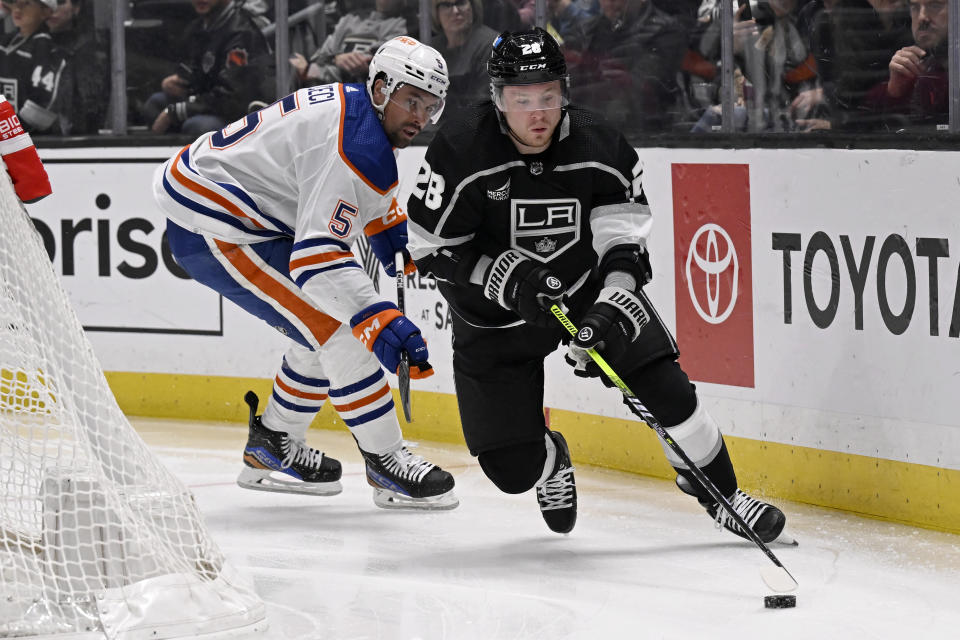 Los Angeles Kings center Jaret Anderson-Dolan (28) controls the puck past Edmonton Oilers defenseman Cody Ceci (5) during the second period of an NHL hockey game in Los Angeles, Saturday, Feb. 10, 2024. (AP Photo/Alex Gallardo)