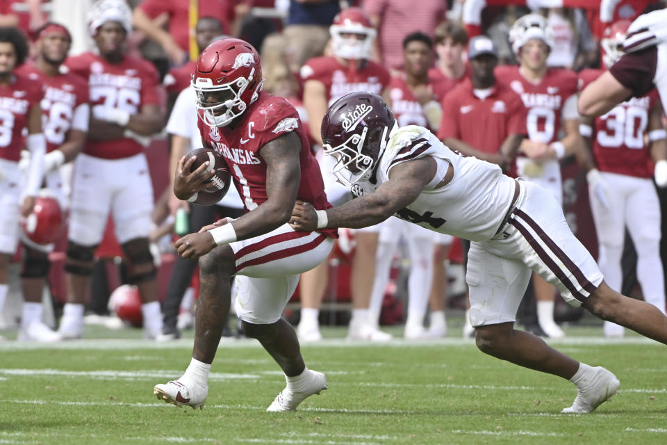 Arkansas quarterback KJ Jefferson (1) tries to slips past Mississippi State linebacker Nathaniel Watson (14) during the second half of an NCAA college football game Saturday, Oct. 21, 2023, in Fayetteville, Ark. (AP Photo/Michael Woods)