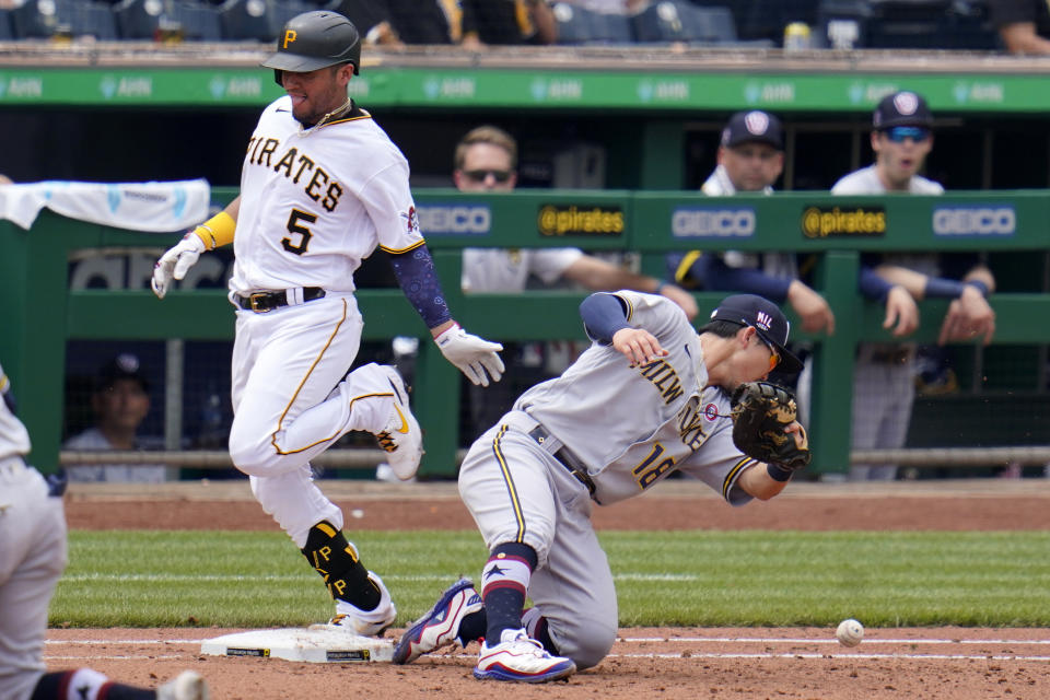 Pittsburgh Pirates' Michael Perez (5) reaches first safely as Milwaukee Brewers second baseman Keston Hiura cannot handle an errant toss by pitcher Freddy Peralta during the fourth inning of a baseball game in Pittsburgh, Sunday, July 4, 2021. (AP Photo/Gene J. Puskar)