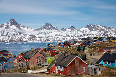 FILE PHOTO: Snow covered mountains rise above the harbour and town of Tasiilaq, Greenland, June 15, 2018. REUTERS/Lucas Jackson/File Photo