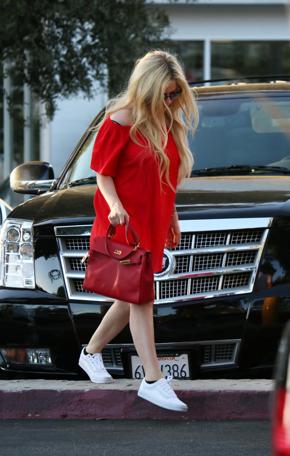 Avril was rocking a chic baggy red dress, with a matching red bag and white trainers. Source: Mega