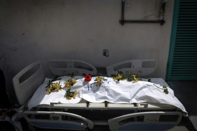 Un cuerpo desenterrado en el Hospital Nasser de Jan Yunis, en el sur de la Franja de Gaza, tapado y cubierto de flores el 23 de abril de 2024 (-)