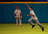 A fan jumped onto the field in the ninth inning and ran past centerfielder Aaron Rowand #33 of the Philadelphia Phillies before surrendering in left field during a game against the Florida Marlins at Dolphin Stadium on April 6, 2007 in Miami, Florida. The Phillies defeated the Marlins 8-2, for their first victory of the season. (Photo by Doug Benc/Getty Images)