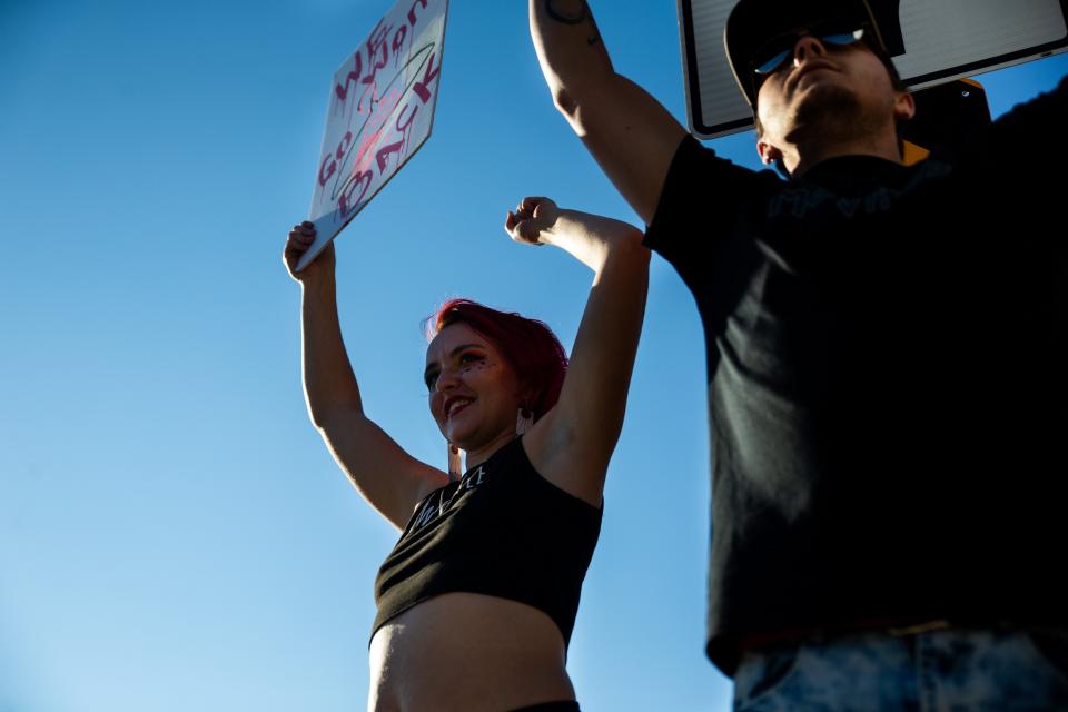 Kristeen Young (left) and her husband Kyle Young hold signs as they protest the Supreme Court's recent decision to overturn Roe v. Wade  Monday, June 27, 2022, in downtown Holland. 
