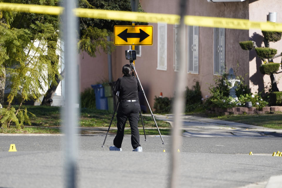 An Inglewood Police forensic investigator scans the street area near the scene of shooting in Inglewood, Calif., Sunday, Jan. 23, 2022. Authorities said several were killed when multiple shooters opened fire at a house party near Los Angeles early Sunday. (AP Photo/Damian Dovarganes)