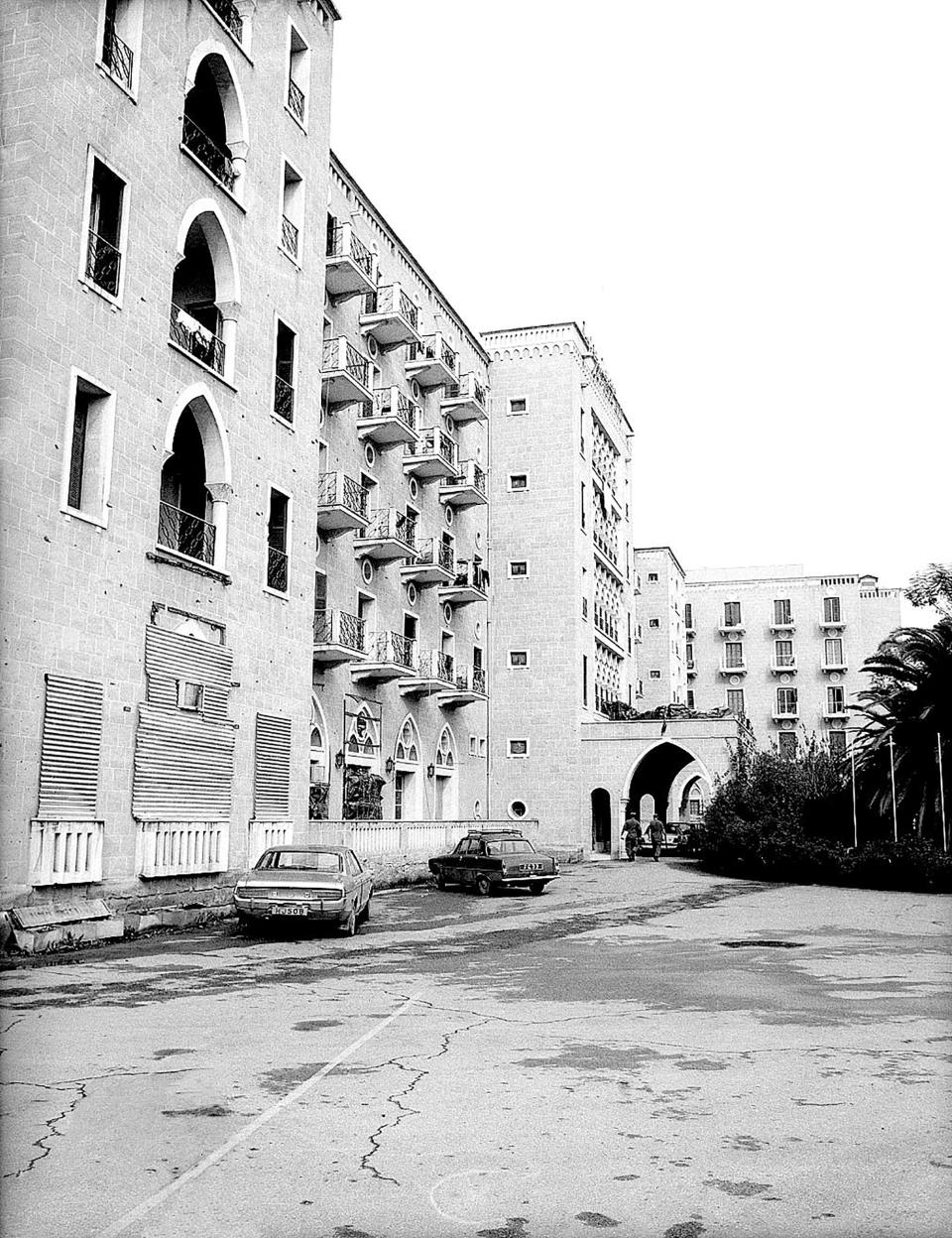 This 1974 photo provided from the Cyprus' press and informations office shows the Ledra Palace Hotel as seen with the holes from bullets during the 1974 coup and the Turkish invasion, in the divided capital Nicosia, Cyprus. This grand hotel still manages to hold onto a flicker of its old majesty despite the mortal shell craters and bullet holes scarring its sandstone facade. Amid war in the summer of 1974 that cleaved Cyprus along ethnic lines, United Nations peacekeepers took over the Ledra Palace Hotel and instantly turned it into an emblem of the east Mediterranean island nation's division. (Press and informations Office via AP)