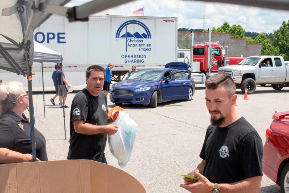 Staff and volunteers with the Christian Appalachian Project distribute bags of snacks with toys, books and games in partnership with Toys for Tots and Good360 at Lawrence County High School in Louisa, Ky., Thursday, June 24, 2021.