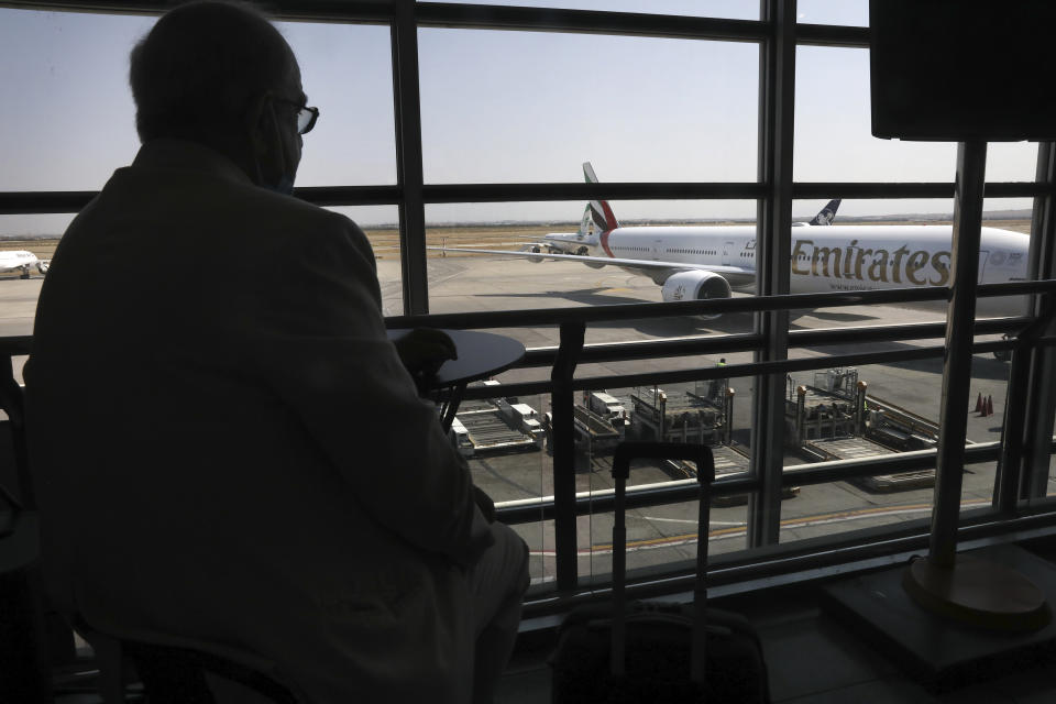 An Emirates plane taxis on the tarmac upon arriving at Tehran's Imam Khomeini airport as a passenger sits at terminal, Iran, Friday, July 17, 2020. The first Emirates flight arrived in Iran after nearly 5 months of suspension of the most airliners flights to the country due to the coronavirus outbreak, as Iranian officials at the airport say they are doing everything possible to ensure passengers are not infected, and isolate those with symptoms. (AP Photo/Vahid Salemi)