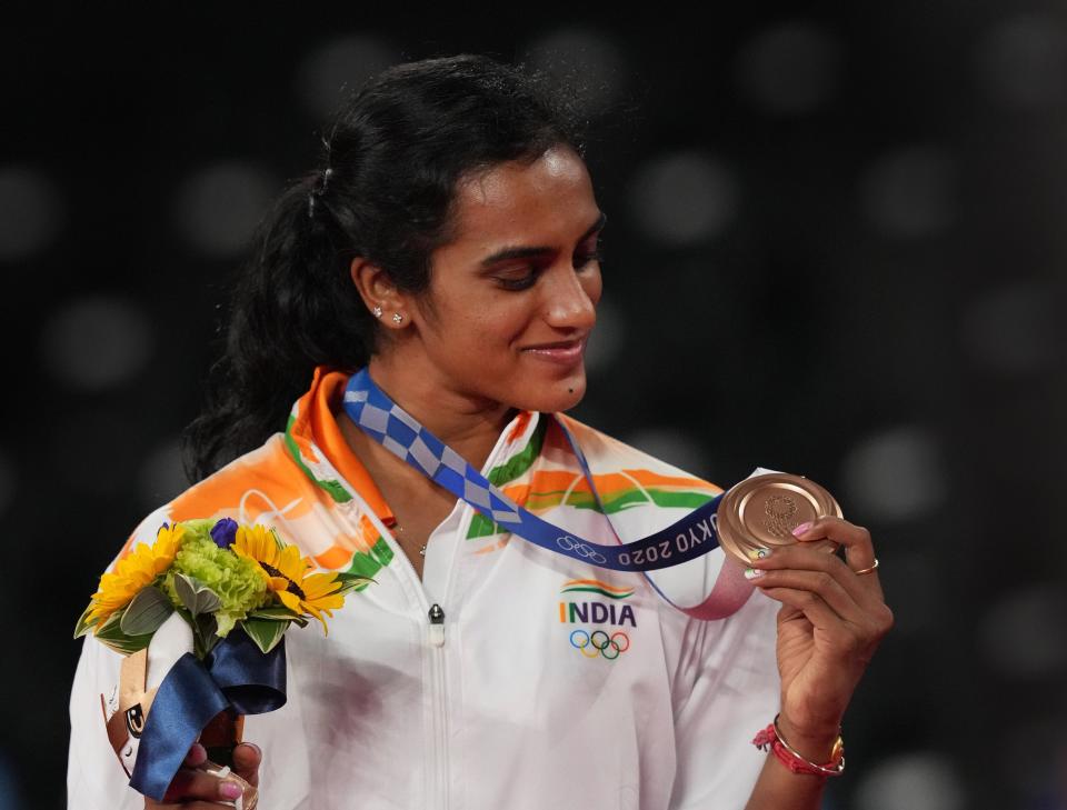 <div class="paragraphs"><p>Tokyo: India's PV Sindhu poses for photographs while standing on the podium after receiving the bronze medal in women's singles badminton event at the Summer Olympics 2020, in Tokyo, Sunday, August 1, 2021. </p></div>