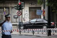 A police officer secures the area around the car of former Greek prime minister and former central bank chief Lucas Papademos following the detonation of an envelope injuring him and his driver, in Athens, Greece, May 25, 2017. REUTERS/Costas Baltas