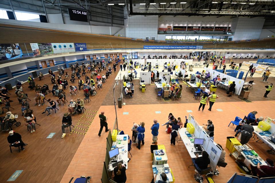 A general view shows various activities as people receive a dose of the BioNTech/Pfizer covid-19 vaccine at a vaccination clinic set up inside the Derby Arena at Pride Park in Derby, Derbyshire on March 31, 2021. - On March 28, 2021, Britain passed the milestone of giving the first vaccine dose to more than 30 million adults, and the government plans to allow outdoor drinking in pub gardens and non-essential retail such as hairdressers in England from April 12. (Photo by Oli SCARFF / AFP) (Photo by OLI SCARFF/AFP via Getty Images)