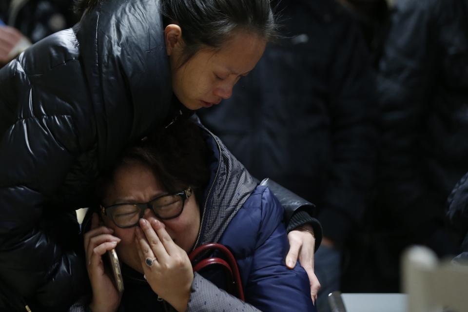 Relatives of a victim hug as they wait at a hospital where people, injured following a stampede incident, are treated in Shanghai