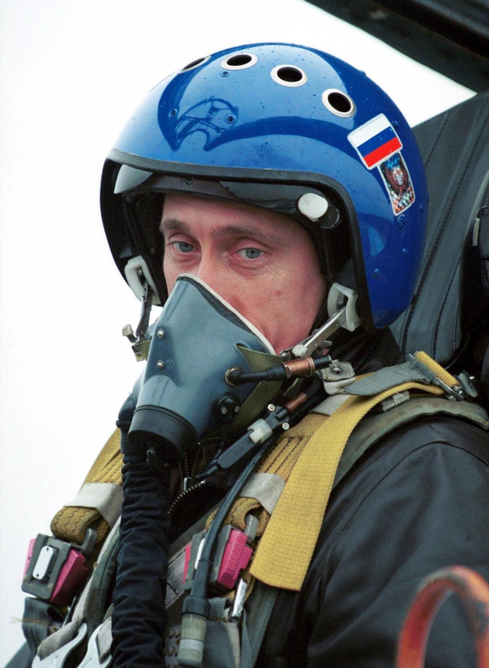 FILE - In this March 20, 2000 file photo, President Vladimir Putin, wearing a blue helmet and an oxygen mask, sits in Su-27 fighter jet after his flight into the war zone in Chechnya, in Grozny, Russia. Putin has become alternately notorious and beloved for an array of adventurous stunts, including posing with a tiger cub and riding a horse bare-chested. (AP Photo/ITAR-TASS, Presidential Press Service, file)