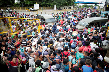 Honduran migrants, part of a caravan trying to reach the U.S., storm a border checkpoint to cross into Mexico, in Tecun Uman, Guatemala October 19, 2018. REUTERS/Ueslei Marcelino