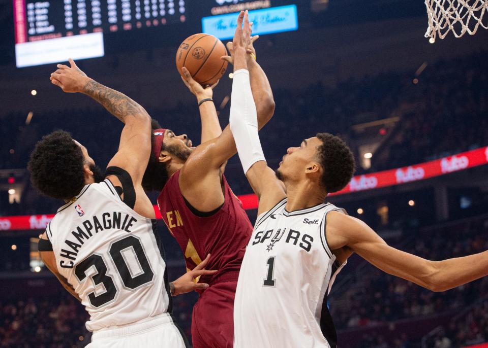 San Antonio Spurs' Victor Wembanyama (1) and Julian Champagnie (30) block Cleveland Cavaliers' Jarrett Allen (31) during the first half of an NBA basketball game in Cleveland, Sunday, Jan. 7, 2024. (AP Photo/Phil Long)