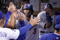 Los Angeles Dodgers' Chris Taylor is congratulated by teammates in the dugout after scoring on a double by Mookie Betts during the second inning of a baseball game against the Colorado Rockies Friday, Sept. 30, 2022, in Los Angeles. (AP Photo/Mark J. Terrill)