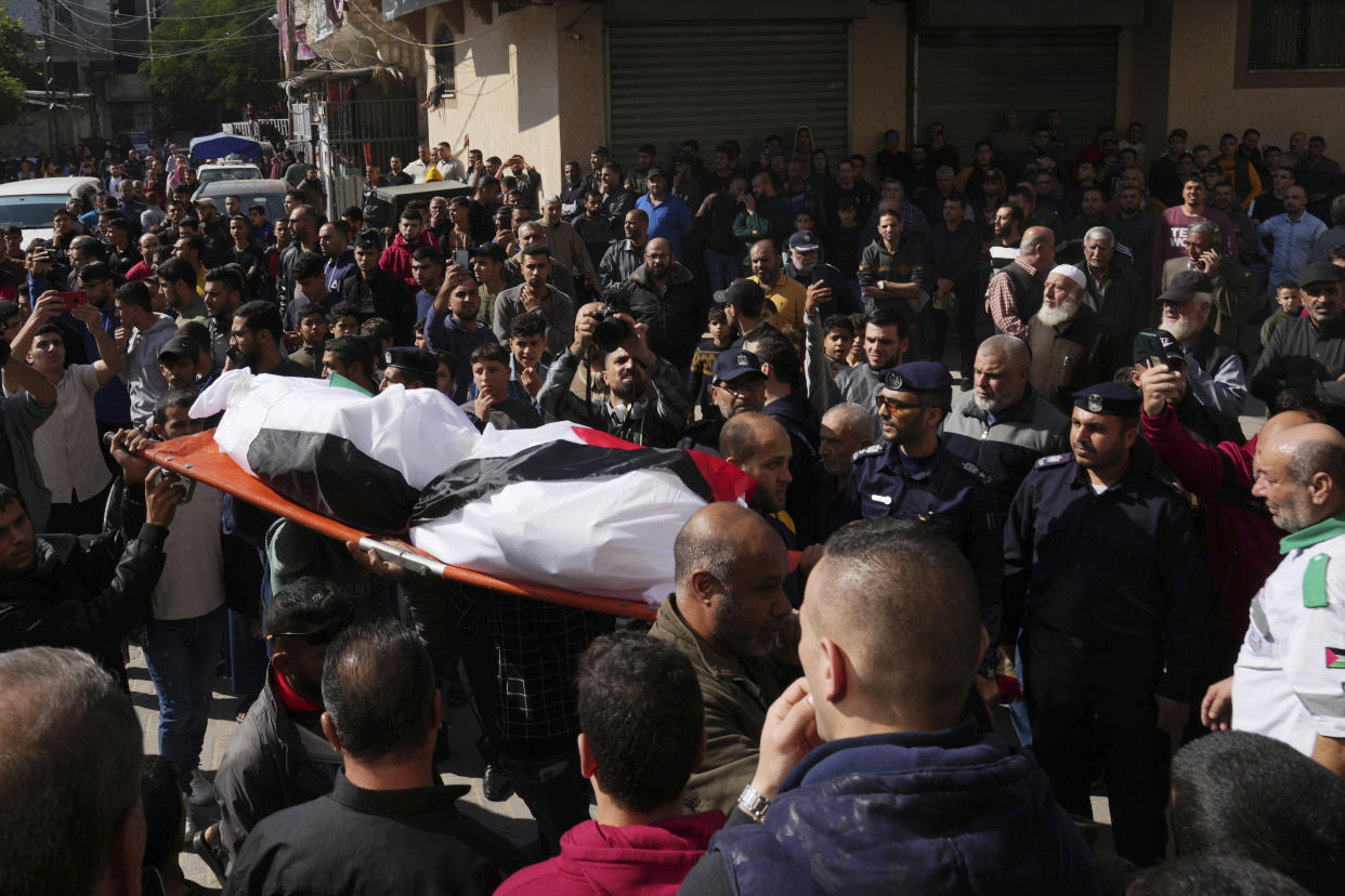Mourners carry a body from 21 bodies of the Abu Raya family who where killed during a fire, during their funeral in front of the mosque in the Jebaliya refugee camp, northern Gaza Strip, Friday, Nov. 18, 2022. A fire set off by stored gasoline in a residential building killed 21 people Thursday evening in a refugee camp in the northern Gaza Strip, the territory's Hamas rulers said, in one of the deadliest incidents in recent years outside the violence stemming from the Israeli-Palestinian conflict. (AP Photo/Adel Hana)